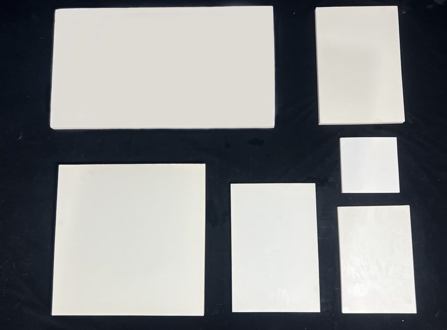 The image shows a square, white 99.7% high‑purity alumina ceramic plate with uniform thickness. It is used as a setter plate for ceramic capacitor sintering, a support plate during piezoelectric ceramic polarization, and other high‑temperature insulation applications. The material has high density and excellent electrical insulation performance.